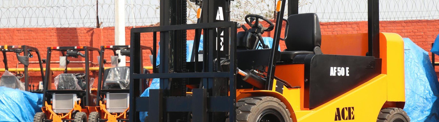 ACE AF50E forklift moving material in an outdoor construction yard
